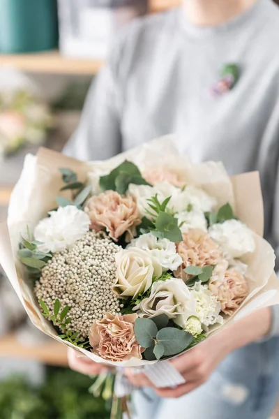 Hermoso ramo fresco cortado de flores mixtas en mano de mujer. el trabajo de la floristería en una florería. Humor de primavera — Foto de Stock