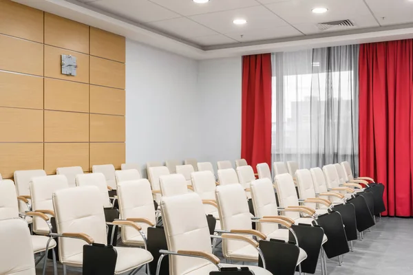 Sala de conferencias moderna vacía en el nuevo hotel. Espacio para entrenamiento, educación, clases grupales, exámenes. Audiencia para ponentes en la convención y presentación de negocios . — Foto de Stock