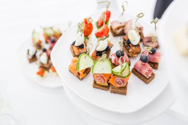 Tablo açık büfe. Ürün yelpazesine kanepeler. Ziyafet Servisi restoranda. Beyaz tabakta yemek catering, aperatifler