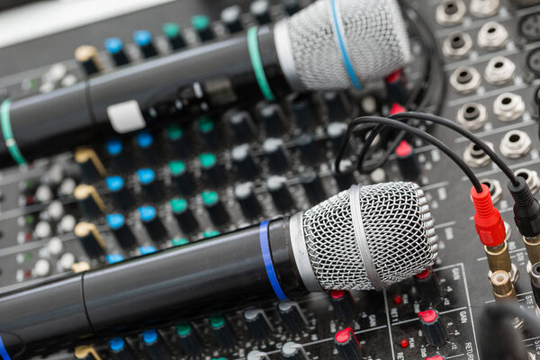 Microphone close-up. Focus on mic. Event concept. Music mixer equalizer console for mixer control sound device. Sound technician audio mixer equalizer control.