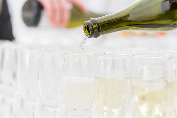 El camarero vierte el champán en las copas. Mesa llena de copas de vino blanco espumoso. Banquete en el restaurante —  Fotos de Stock