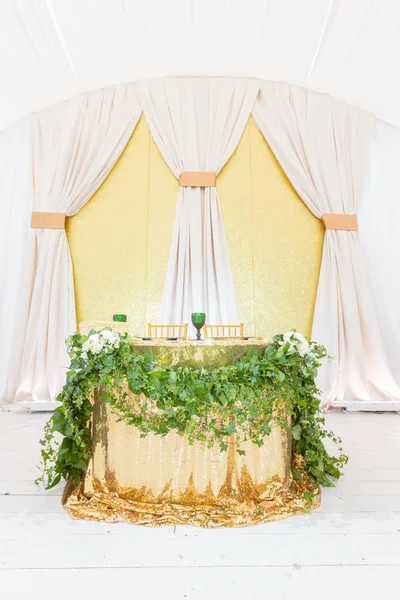 新婚夫婦のテーブル。黄金料理、緑ワイン グラス、ナプキン。ケータリングのコンセプトです。結婚式のディナー、ゲストの準備のためのテントの内部。ラウンド バンケット テーブルを提供しています. — ストック写真