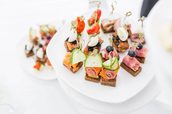 Mesa de bufete. Sortimento de canapés. Serviço de banquete no restaurante. Comida de restauração, lanches em prato branco — Fotografia de Stock