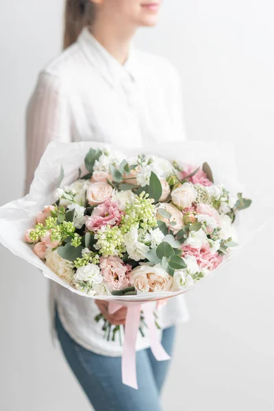 Beautiful fresh cut bouquet of mixed flowers in woman hand. the work of the florist at a flower shop. Delicate Pastel tones color — Stock Photo, Image