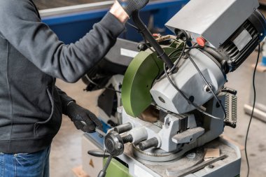 alt malzeme bir parçası olan bir daire testere makinesi keser. Keskin, dairesel testere ile bir metal ve çelik ile bileşik gönye kesim üzerinde çalışan mühendis