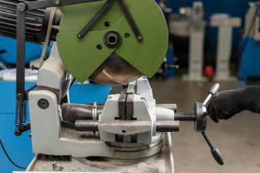 alt malzeme bir parçası olan bir daire testere makinesi keser. Keskin, dairesel testere ile bir metal ve çelik ile bileşik gönye kesim üzerinde çalışan mühendis