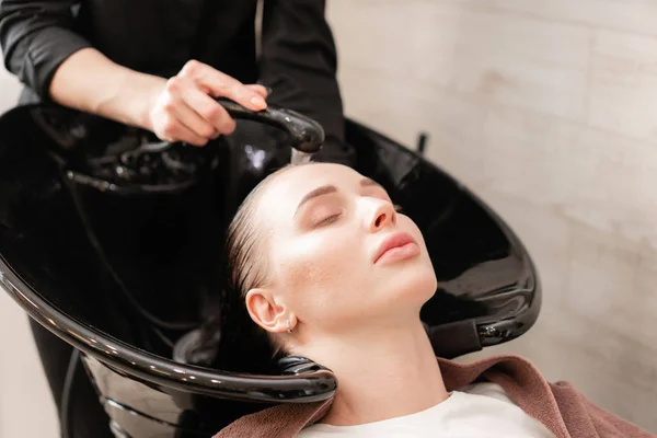 Krásná holka myje vlasy před účes v salonu krásy. vlasy mytí v kadeřnictví. Profesionální šampon. Stylový Kadeřnictví — Stock fotografie