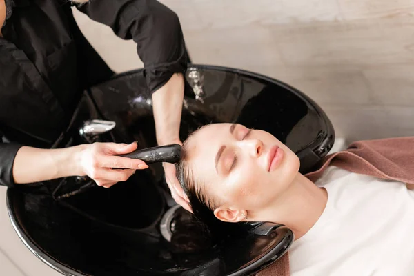 Krásná holka myje vlasy před účes v salonu krásy. vlasy mytí v kadeřnictví. Profesionální šampon. Stylový Kadeřnictví — Stock fotografie
