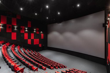 Rusya, Nizhny Novgorod - 14 Kasım 2016: Sinema Imperia Grez Nebo, Dolby atmosferini boş kırmızı sinema salonu sandalye, yumuşak ve rahat sandalyeler. Ekranda beyaz boşluk ile perspektif oditoryum görüntülemek