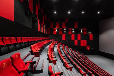 Rusya, Nizhny Novgorod - 14 Kasım 2016: Sinema Imperia Grez Nebo, Dolby atmosferini boş kırmızı sinema salonu sandalye, yumuşak ve rahat sandalyeler. Ekranda beyaz boşluk ile perspektif oditoryum görüntülemek