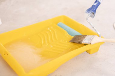 Beton yüzeyine boya fırçası, silindir ve yapıştırıcı kapsayıcı. Kompozisyon araçları ev onarım ve iç yenileme kapalı.