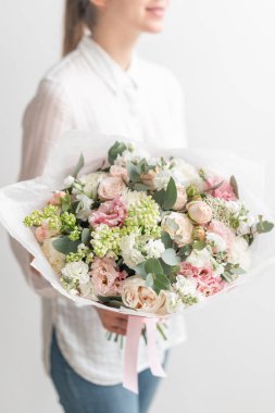 güzel taze karışık çiçekli buket kadın elinde kesilmiş. Çiçekçi Çiçek dükkanında çalışır. Hassas Pastel tonları renk