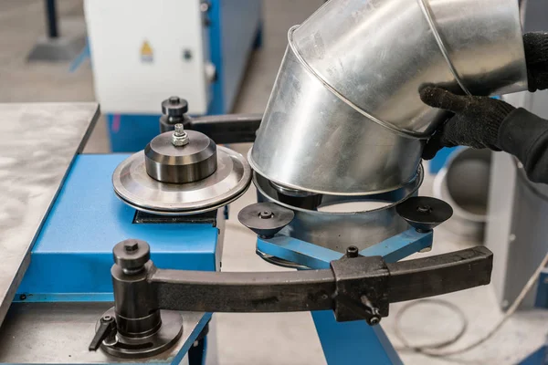 O trabalhador controla a máquina. Ferramenta de rolamento de produção, máquina elétrica. a produção de ventilação e calhas. Ferramenta e equipamento de dobra para chapa metálica . — Fotografia de Stock