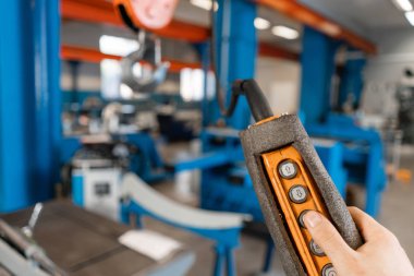 üretim Vinç uzaktan kumanda. Depodaki bir vinç ile çalışan işçiler... Havalandırma ve oluklar üretimi. Aracı ve Sac bükme donatımı.