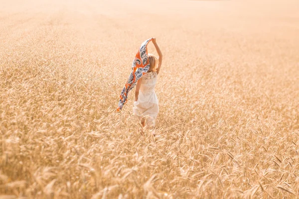 Modelo de menina loira em um campo de trigo. Uma jovem que gosta da natureza. Menina bonita correndo nos raios de luz solar. Luz solar . — Fotografia de Stock