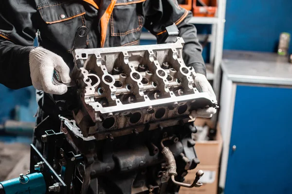 Mecánico de desmontaje del motor, revisión.. Motor en un soporte de reparación con pistón y varilla de conexión de la tecnología automotriz. Interior de un taller de reparación de automóviles . — Foto de Stock