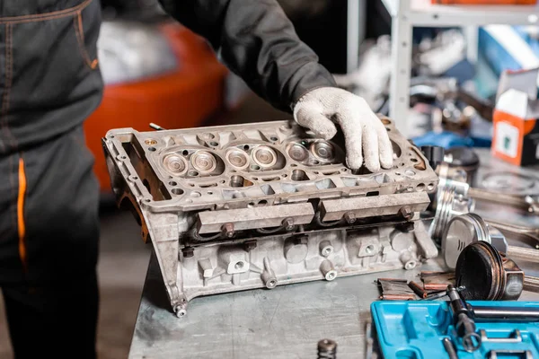 Mecánico de desmontaje del motor, revisión.. Motor en un soporte de reparación con pistón y varilla de conexión de la tecnología automotriz. Interior de un taller de reparación de automóviles . — Foto de Stock