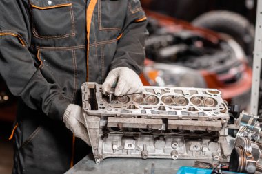 Tamirci yeni bir vana yükler. Motor bloğu araç sökmeye. Motor sermaye onarım. 16 valf ve dört silindirli. Araba hizmet anlayışı.