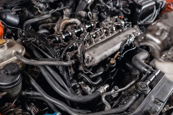 Primer plano del motor diesel del coche. El maestro repara el coche en el garaje. Servicio de reparación de vehículos —  Fotos de Stock