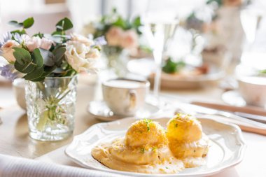 Yumurta Benedict sıcak tost çörek. İki yumurta lezzetli Hollandaise sosu. Hafif sabah restoranda masada kahvaltı.