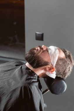 Berber sakal şekli yapıyor. Sakal kesme, yüz bakımı. Berber dükkanı salonunda çalışmak.