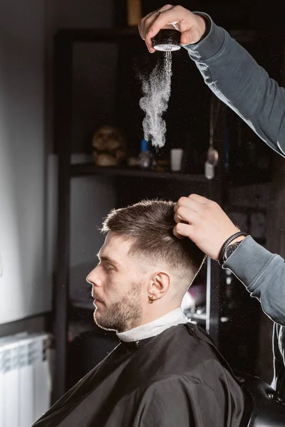 Usta berber saç düzeltmek için şekillendirme tozu döker. kuaför genç bir adam için saç modeli yapar. — Stok fotoğraf