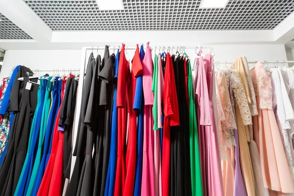 Коктейльное платье. Одежда на вешалке в современном бутике. Яркие разноцветные ткани. Концепция покупок . — стоковое фото