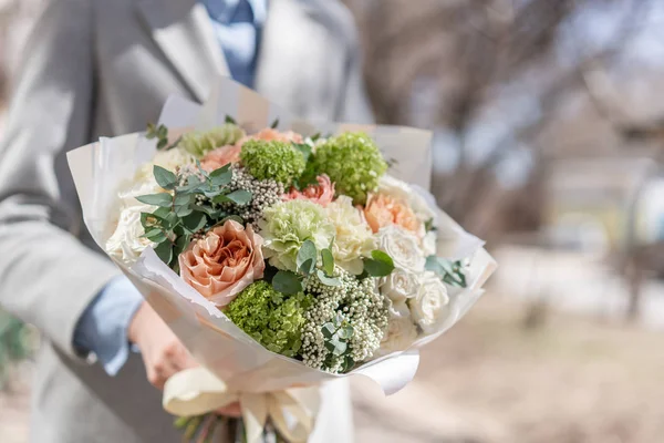 Belo buquê de corte fresco de flores mistas na mão da mulher. o trabalho da florista em uma loja de flores. Delicado tons pastel cor — Fotografia de Stock