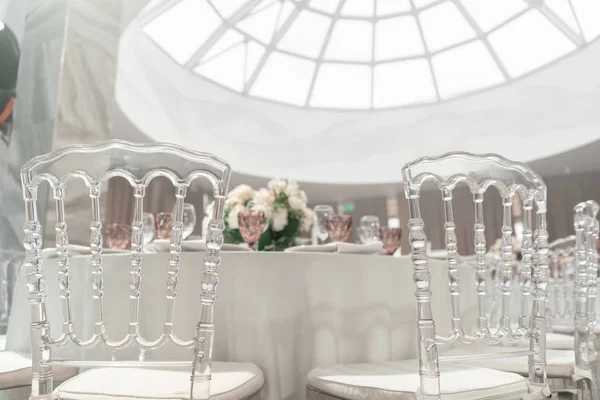 Table ronde de banquet servi. Intérieur du restaurant pour le dîner de mariage, prêt pour les invités. Décoré avec un arrangement floral. Plats, verres à vin et serviettes. Concept de restauration . — Photo