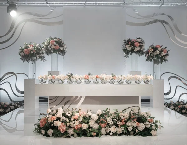 Den Tisch der Frischvermählten. kleine Blumenarrangements in Kugelglasvasen. Innenraum des Restaurants für Hochzeitsessen, bereit für die Gäste. Catering-Konzept. — Stockfoto