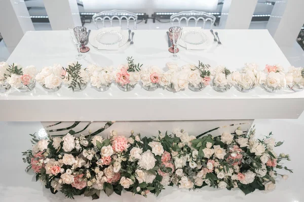 La mesa de los recién casados. Pequeños arreglos florales en jarrones de vidrio de bola. Interior del restaurante para la cena de bodas, listo para los huéspedes. Concepto de restauración . — Foto de Stock