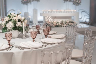 Masanın ortasında çiçek aranjmanı. Düğün yemeği için restoranın iç, misafirler için hazır. Yuvarlak Ziyafet masası servis edilir. Catering konsepti.
