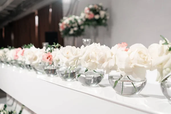 Pequeños arreglos florales en jarrones de vidrio de bola. La mesa de los recién casados. Interior del restaurante para la cena de bodas, listo para los huéspedes. Concepto de restauración . —  Fotos de Stock
