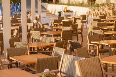 Kafede masalar. Sahilde yaz gündoğumu, Korfu Adası, Yunanistan. Anakara Yunanistan Dağları 'nın mükemmel manzarasına sahip şezlong ve şemsiyeler ile plaj.