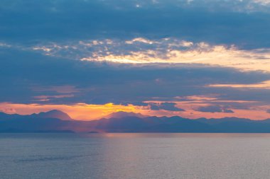 Summer sunrise on coast, Corfu island, Greece. Beach with perfect views of the mainland Greece mountains.