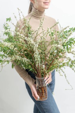 Blooming Spirea, vazibir kadın elinde. Pamuk Prenses. Çiçekçilik, çiçekçilik konsepti