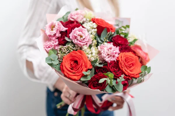 Schöner Strauß gemischter Blumen in Frauenhänden. die Arbeit des Blumenhändlers in einem Blumenladen. zarte Pastellfarbe. frische Schnittblume. rote und rosa Farbe — Stockfoto