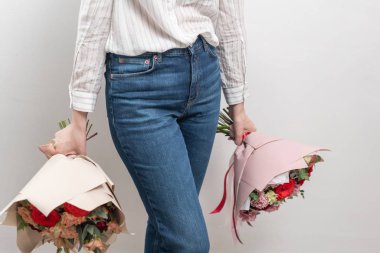 kadın elinde karışık çiçek iki Güzel buketleri. bir çiçekçi de çiçekçi çalışmaları. Narin Pastel rengi. Taze kesilmiş çiçek. Kırmızı ve şeftali rengi