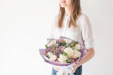 Kadın elinde karışık çiçek güzel buket. bir çiçekçi de çiçekçi çalışmaları. Narin Pastel rengi. Taze kesilmiş çiçek. Beyaz ve leylak rengi