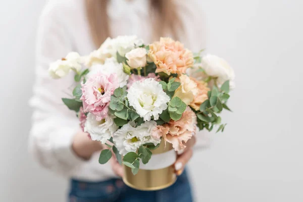 Beautiful floral arrangement of mixed flowers in woman hand. Golden flowerpot. The work of the florist at a flower shop. Delicate Pastel color. Fresh cut flower. — Stock Photo, Image