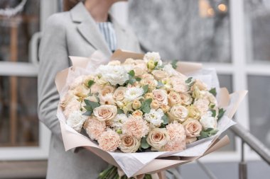 Kadın elinde karışık çiçek Büyük Güzel buket. Pembe ve beyaz renkte. bir çiçekçi de çiçekçi çalışmaları. Narin Pastel rengi. Taze kesilmiş çiçek.