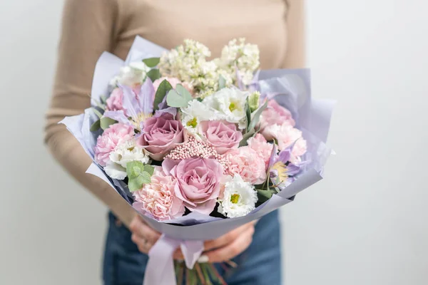 Bellissimo bouquet di fiori misti in mano donna. il lavoro del fioraio in un negozio di fiori. Colore pastello delicato. Fiore reciso fresco. Colore rosa e lilla — Foto Stock