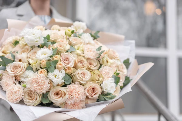 Large Beautiful bouquet of mixed flowers in woman hand. Pink and white color. the work of the florist at a flower shop. Delicate Pastel color. Fresh cut flower.