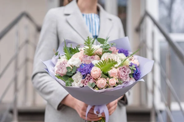 Kadın elinde karışık çiçek Güzel buket. Pembe ve beyaz renkte. bir çiçekçi de çiçekçi çalışmaları. Narin Pastel rengi. Taze kesilmiş çiçek.