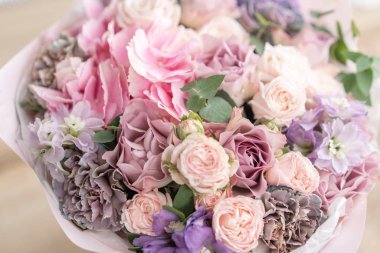 Ahşap masa üzerinde karışık çiçek güzel buket. bir çiçekçi de çiçekçi çalışmaları. Narin Pastel rengi. Taze kesilmiş çiçek. Pembe ve leylak rengi