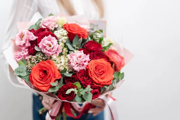 Beautiful bouquet of mixed flowers in womans hands. the work of the florist at a flower shop. Delicate Pastel color. Fresh cut flower. Red and pink color — Stock Photo, Image