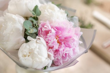 Metal bir vazoda beyaz ve pembe şakayıklar. Katalog ya da internet mağazası için güzel şakayık çiçekleri. Çiçek dükkanı konsepti. Taze kesilmiş güzel bir buket. Çiçek teslimatı