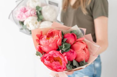 İki güzel buket. Mercan ve beyaz şakayıklar kadın ellerinde. Katalog veya online mağaza için güzel şakayık çiçek. Çiçek dükkanı konsepti . Taze kesim Çiçekler teslimat