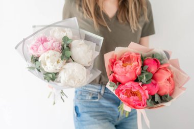 İki güzel buket. Mercan ve beyaz şakayıklar kadın ellerinde. Katalog veya online mağaza için güzel şakayık çiçek. Çiçek dükkanı konsepti . Taze kesim Çiçekler teslimat