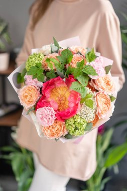 Kadın elinde karışık çiçek Küçük Güzel buket. Çiçek dükkanı konsepti . Güzel taze kesme buketi. Çiçek teslimatı
